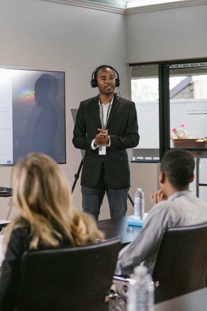 A professional delivers a presentation to a diverse audience in a conference room.